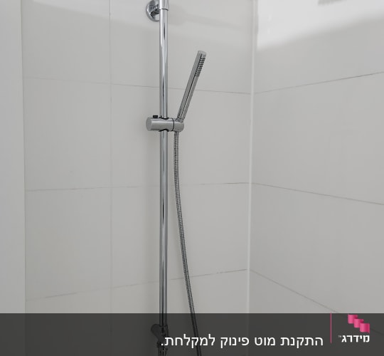 ראש מקלחת וכיור בחדר אמבטיה